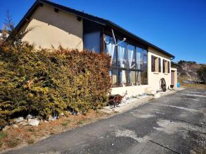 a building with a dog sitting outside of it at Maison de montagne FONT ROMEU in Font Romeu Odeillo Via