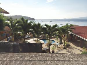 a view of a resort with palm trees and a swimming pool at Oriental Hill Sabang Resort Puerto Galera in Puerto Galera