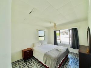 ein Schlafzimmer mit einem weißen Bett und einem Fenster in der Unterkunft Ocean Cottage Private Double Twin Room in Nuku'alofa Town in Nuku‘alofa