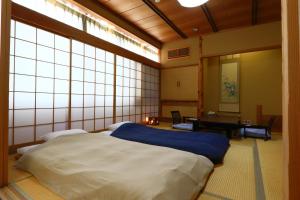 Ōmiya割烹旅館小川荘的带大窗户的客房内设有一张大床的卧室
