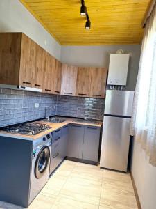 Il comprend une cuisine équipée d'un réfrigérateur et d'une cuisinière. four supérieur dans l'établissement Natos Cottage, à Sadgeri