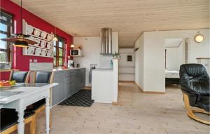 een keuken met rode en witte muren en een tafel en stoelen bij 1 Bedroom Stunning Home In Allingåbro in Allingåbro