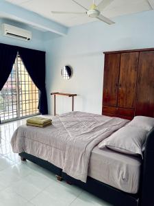 a bedroom with a large bed with a wooden headboard at D Ocean Homestay in Seri Manjung