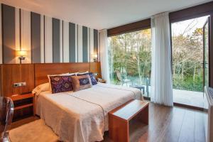 ein Schlafzimmer mit einem Bett und einem großen Fenster in der Unterkunft Hotel Alén do Mar in Kap Finisterre