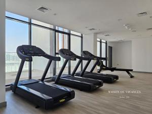 a row of treadmills in a gym with windows at Santorini Studio Pool View in Dubai