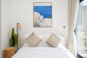 a bedroom with a white bed and a window at Santorini Studio Pool View in Dubai