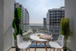 a balcony with a table and chairs and a view of a city at Santorini Studio Pool View in Dubai