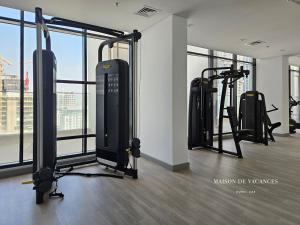 a gym with a bunch of tread machines in a room at Santorini Studio Pool View in Dubai