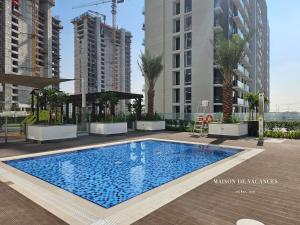 a swimming pool in a city with tall buildings at Santorini Studio Pool View in Dubai