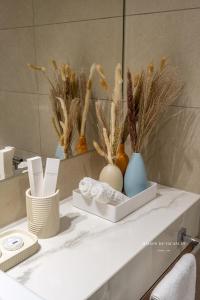 a white shelf with vases and flowers on it at Santorini Studio Pool View in Dubai
