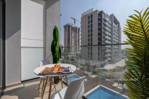 a balcony with a table and a view of a building at Santorini Studio Pool View in Dubai
