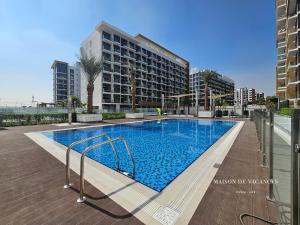 a large swimming pool in front of a building at Santorini Studio Pool View in Dubai