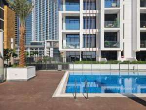 a swimming pool in front of a building at Santorini Studio Pool View in Dubai