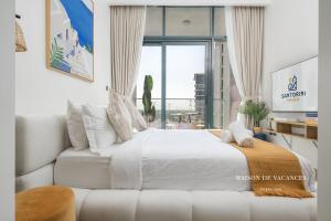 a bedroom with a white bed and a large window at Santorini Studio Pool View in Dubai +22 photos
