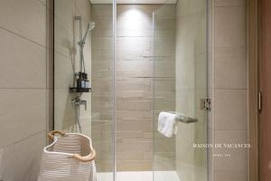 a bathroom with a shower with a glass door at Santorini Studio Pool View in Dubai