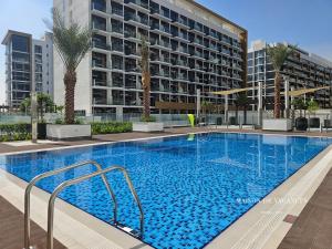 a large swimming pool in front of a large building at Santorini Studio Pool View in Dubai