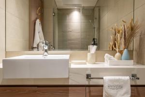 a bathroom with a white sink and a mirror at Santorini Studio Pool View in Dubai