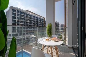 a table with a plate of food on a balcony at Santorini Studio Pool View in Dubai