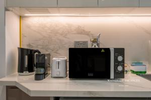 a counter with a microwave and other appliances on it at Santorini Studio Pool View in Dubai