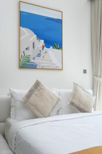 a living room with a white couch with a painting on the wall at Santorini Studio Pool View in Dubai