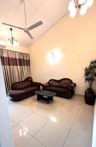 a living room with two couches and a table at Cozy Homestay in Ipoh