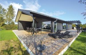 a house with a wooden deck with a fire pit at Four-Bedroom Holiday Home In Haderslev in Haderslev