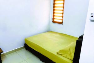 a small bed in a room with a window at Cozy Homestay in Ipoh