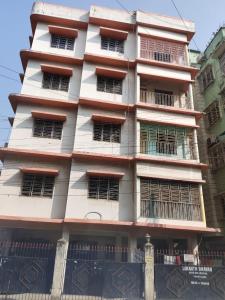 a tall white building with barred windows at Homely Stay in Kolkata