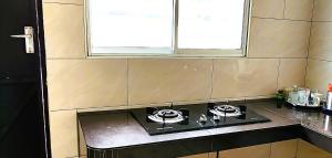 a stove top in a kitchen with a window at Cozy Homestay in Ipoh