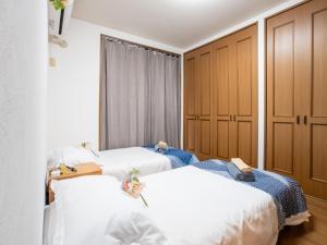 two beds in a room with wooden cabinets at Happy House 西小岩 京成小岩駅徒歩5分 in Tokyo