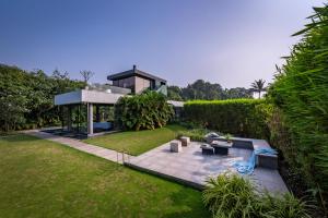 En have udenfor SaffronStays Glasshouse 91 - 4BR luxury villa with pool, art installations, lawns & outdoor dining