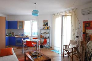 sala de estar con mesa y sillas y cocina en Roccesarde Apartment, en Alghero