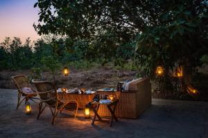 two chairs and a table with a television and lights at Bagh Villas I Kanha in Kānha