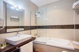uma casa de banho com um lavatório e uma cabina de duche em vidro. em Hotel Alén do Mar em Finisterre