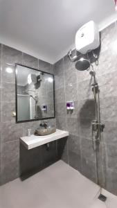 a bathroom with a sink and a mirror at Hotel Green Prundi in Labuan Bajo
