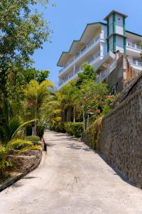a path in front of a building with trees at Hotel Green Prundi in Labuan Bajo