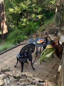 a table and chair with two glasses of wine at Williams River Retreat in Dungog