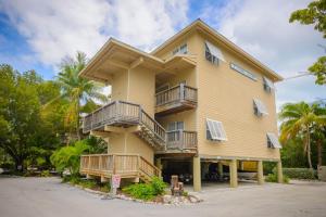 a yellow building with balconies and palm trees at Coconut Mallory Resort and Marina in Key West