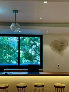 a room with chairs and a large window with a fan at Mumune Stay in Seoul