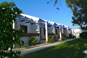 una fila de casas blancas con pérgolas azules en Hotel Rural Terrablanca, en Villablanca