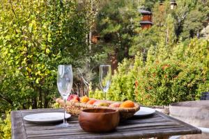 a table with a basket of fruit and two wine glasses at Enchanted Waterfall Sanctuary in Mill Valley +42 photos