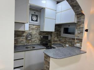 a kitchen with white cabinets and a sink at BePy's NUBIAN HOUSE in Aswan