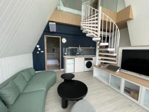 a living room with a couch and a spiral staircase at 朵2包棟Villa in Xiaoliuqiu
