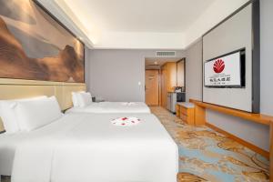 Postel nebo postele na pokoji v ubytování Zhangzhou Yuyuan Hotel