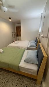 two beds in a small room with at 5 Minutes Airport Lodge in Kampong Patagas +2 photos