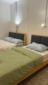 two beds sitting next to each other in a room at 5 Minutes Airport Lodge in Kampong Patagas