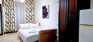 a small room with a bed and a refrigerator at Isabell Home in Iaşi