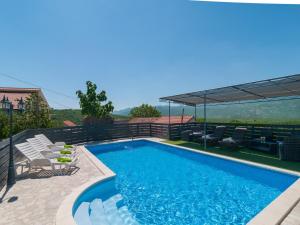 a swimming pool with chairs and a patioitures at Villa Homeland in Imotski