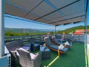 a patio with chairs and tables on a roof at Villa Homeland in Imotski