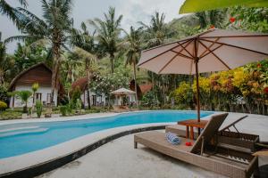 a resort pool with a table and an umbrella at Crystal Bay Villa in Nusa Penida